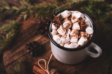 Metal mug of hot chocolate with marshmallows on wooden background. Сinnamon and star anise.