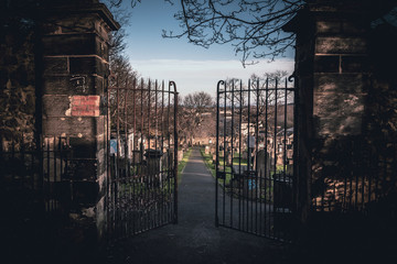EDINBURGH, SCOTLAND DECEMBER 14, 2018: path to an entrance of a graveyard with a open wrought-iron...
