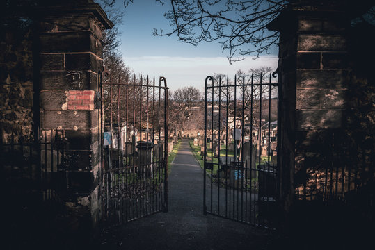 EDINBURGH, SCOTLAND DECEMBER 14, 2018: path to an entrance of a graveyard with a open wrought-iron gate
