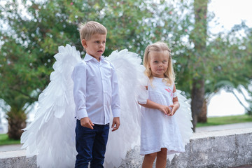 Children dressed as angels walk in the park