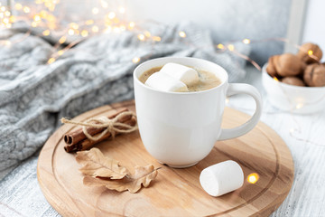 Mug with coffee and marshmallow, sweater, cinnamon, decorated with led lights. Autumn mood. Cozy autumn composition. Hygge concept Soft focus - Image