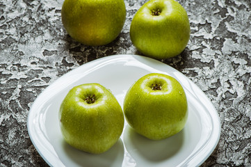 Apples in a plate than a knife. Fresh yellow apples.