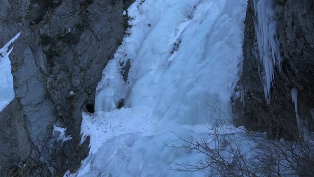 Panning shot of two of the many frozen waterfall cascades in the Dabaklamm, a very steep and narrow gorge in the Hohe Tauern nature reserve mountain region, Tirol Austria making the way unpassable in 