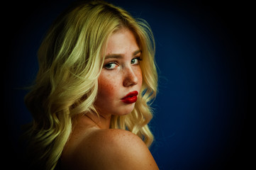 Portrait of blond girl young woman with freckles and blue eyes