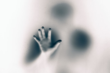 Creepy man holding the frosted glass with one hand.