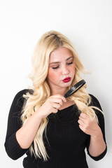 Naklejka premium Blond young woman hair problems, girl with blue eyes and freckle holding magnifier and scissor unhappy dry and damaged hair concept hair care