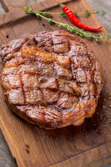 Rib eye steak on wooden board, closeup