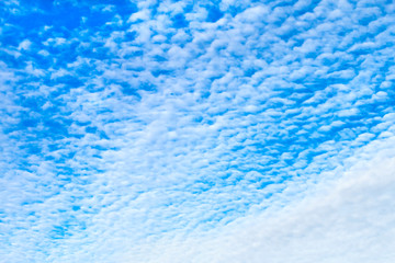 Beautiful white fluffy cirrus clouds in the clear blue sky in the early morning.
