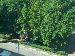 The electrician changes the lamp on the light pole, the car-tower lifts the worker to the pole to...