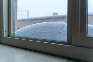 Window with snow accumulated on the lower part