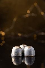Art chocolate white and gold candies on glossy background. Selected Focus