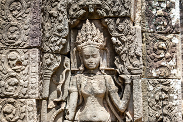 Fototapeta na wymiar Siem Reap / Cambodia - May 27 / 2019 : engraving of a female god on the walls of bayon temple at angkor wat temple complex
