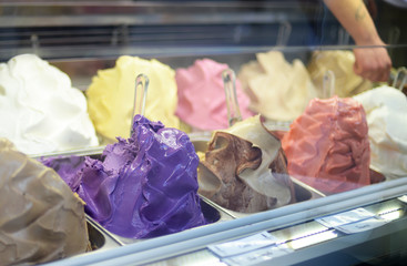 Italian ice cream display with most prominent the purple 'uva fragola' or Concord grape variety. Selective focus