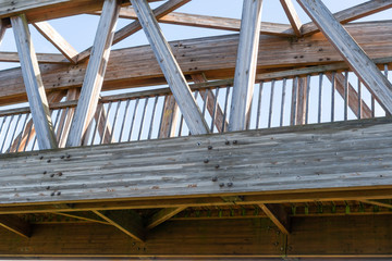 Wooden plank bridge with railing on a background of blue clear sky