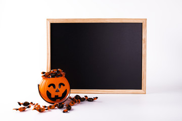 Halloween blackboard and pumpkin full of candies