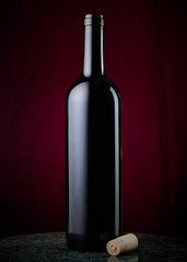 Open wine bottle and cork in low light setting