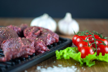fresh grilled meat with cherry tomatoes, lettuce, garlic and seasonings