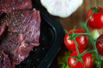 fresh grilled meat with cherry tomatoes, lettuce, garlic and seasonings