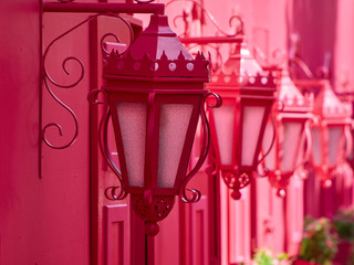 Close-up of pinky street lamps on a pink wall. Romantic pink street.
