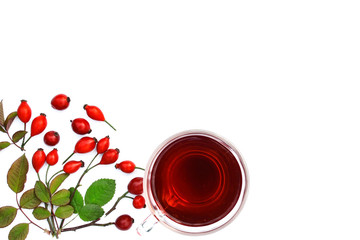 Rosehip tea surrounded by fruit and leaves on a white background