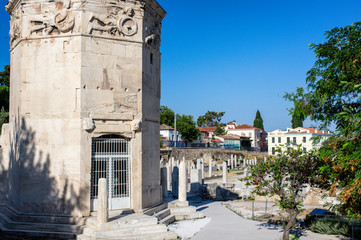 Fototapeta na wymiar Athens / Greece - August 10 / 2019 : octogonal shaped tower of the wind at roman agora