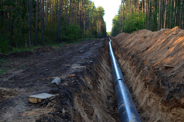 Natural gas pipeline construction work. A dug trench in the ground for the installation and...