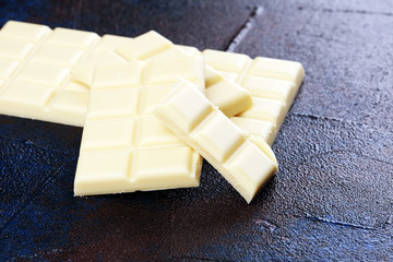 white broken chocolate and cocoa bar. Pieces of white chocolate on rustic background