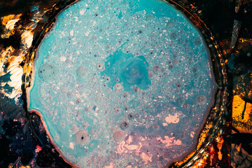 Abstract art background. Blue colored enamel in clear glass plate. Bubbled textured surface.