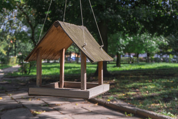 bird feeder in the form of a house hanging on a tree in Park