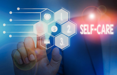 Writing note showing Self Care. Business concept for the practice of taking action to improve one s is own health Male wear formal suit presenting presentation smart device