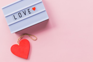 Romantic gesture, love confession, happy valentines day, light box lettering, greeting card. Red heart on pink background. Copy space.Photo of a light box with text, LOVE.