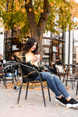  beautiful girl in yellow sweater drinking coffee outside