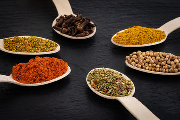 Colourful various herbs and spices on dark background