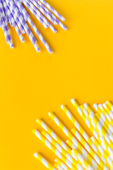 Celebration pattern flat lay,holiday celebration drinking cocktail party straws.Template for greeting card,design.Eco,reusable, paper, striped straw for drinking juice or cocktail on yellow background
