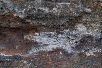 Texture, stone it can be used as a background.  Fragment of a multi-colored stone with scratches and cracks.