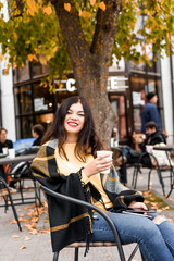 Obraz na płótnie Canvas beautiful girl in yellow sweater drinking coffee outside