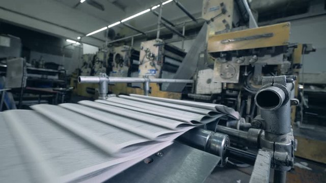 Paper with printed text is getting transported by the conveyor