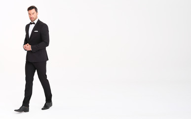 Handsome man in classic black suit looks very elegant.