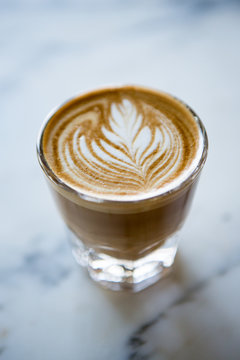 Cup of cortado over marble surface.