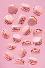 Fototapeta premium Pattern of sweets made of pink macaroons, sweets on a pink background. Pattern of pink macaroons.