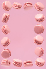 Frame of sweets made of pink macaroons, sweets on a pink background. Pattern of pink macaroons.