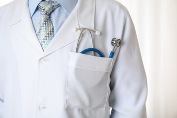 Doctor in medical gown with blue stethoscope, close up