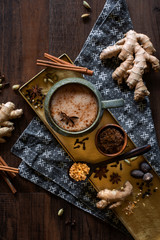 chai tea spices flat lay, chai tea latte with ginger root, cinnamon sticks, cardamom pods, star...
