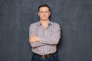Obraz premium Portrait of focused serious man holding arms crossed on chest