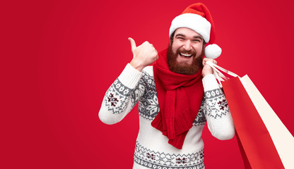 Man with Christmas purchases pointing aside