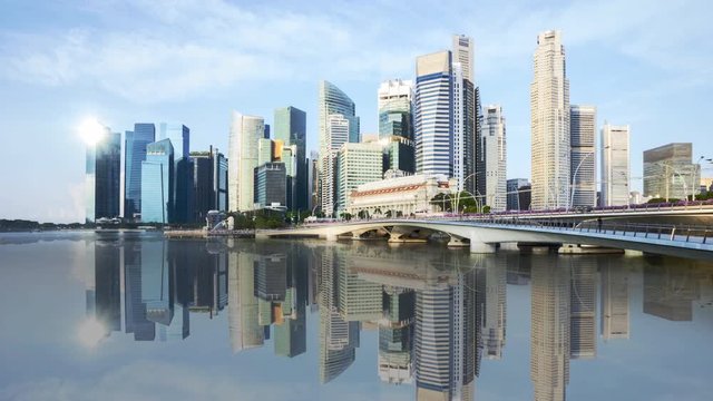 4k time lapse of sunrise at Singapore city skyline with water reflection effect. Panning left