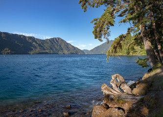 Lake Crescent, deep lake located entirely within Olympic National Park - view from Olympic National Park Highway. Sunny day, blue water, panoramic view. Clallam County, Washington, United States.