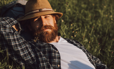 Relaxed tourist chewing straw on lawn
