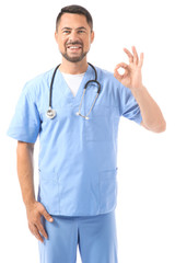 Fototapeta premium Portrait of male doctor showing OK on white background