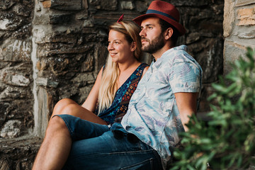 Young couple sitting on the stairs in an old village in Greece
